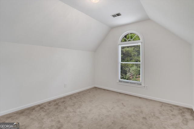 bonus room with light carpet and vaulted ceiling