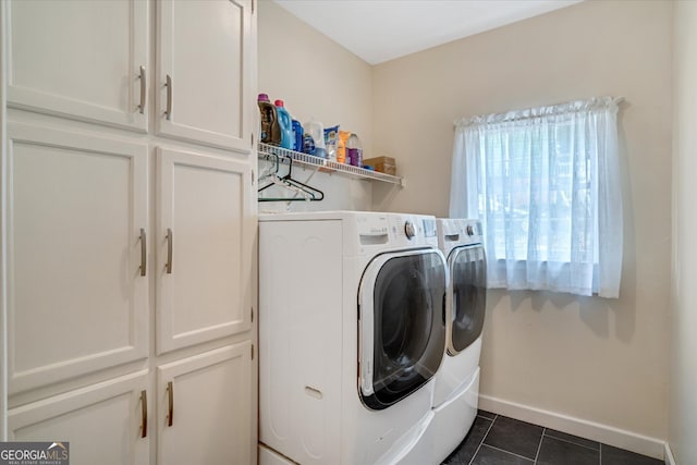 laundry area with cabinets, washing machine and dryer, and dark tile patterned flooring