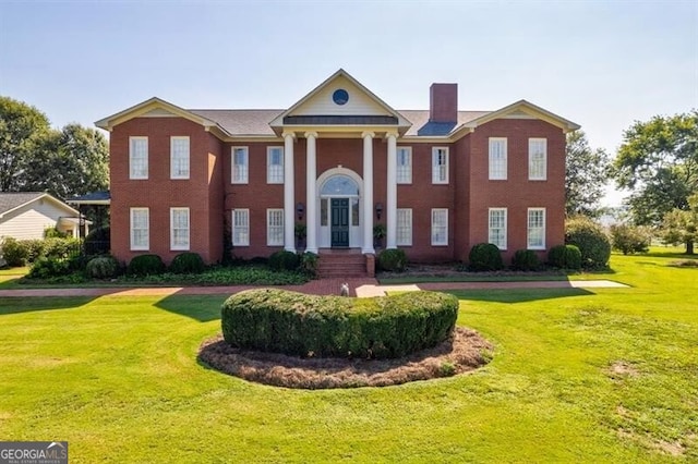 neoclassical / greek revival house featuring a front yard