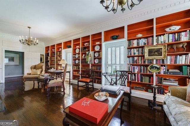 sitting room with dark hardwood / wood-style floors, a notable chandelier, and ornamental molding