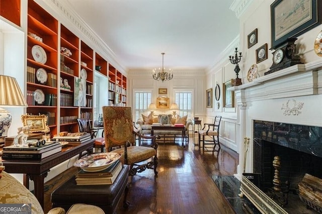 interior space featuring a fireplace, ornamental molding, a chandelier, and hardwood / wood-style floors