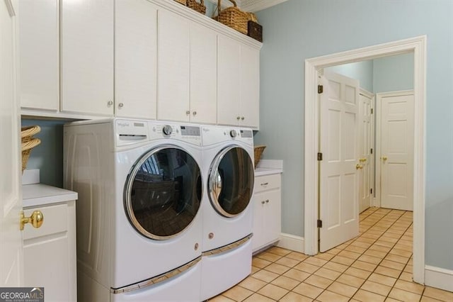 laundry room with light tile patterned flooring, washing machine and dryer, and cabinets