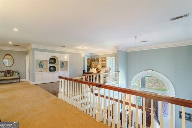 hall with plenty of natural light, crown molding, and carpet flooring