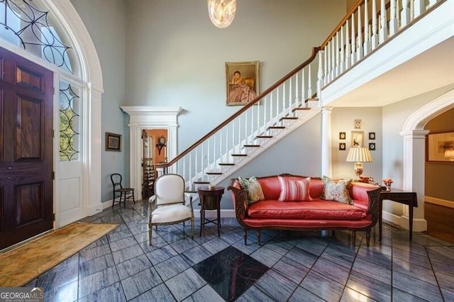 tiled entrance foyer with a towering ceiling and ornate columns