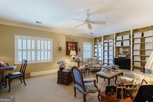 carpeted office space with crown molding and ceiling fan