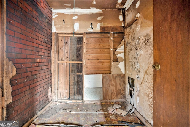 bathroom featuring brick wall