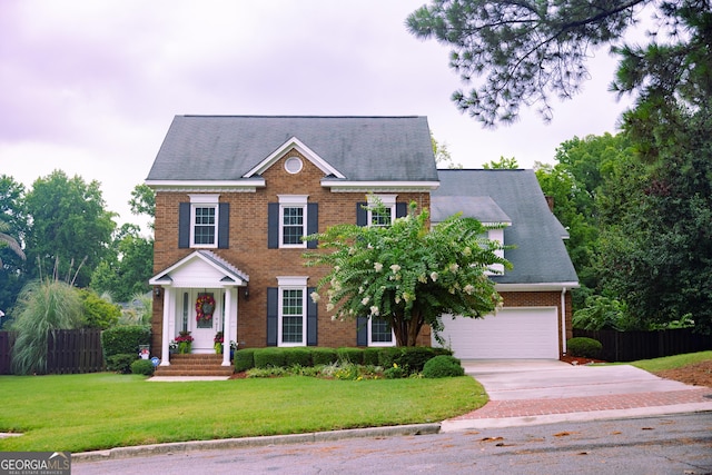 colonial inspired home featuring a garage and a front yard