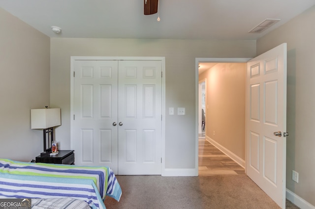 carpeted bedroom featuring ceiling fan and a closet