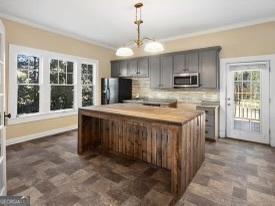 kitchen with dark tile patterned flooring, decorative backsplash, refrigerator, and a kitchen island