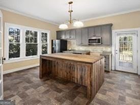 kitchen with tasteful backsplash, a center island, ornamental molding, and refrigerator