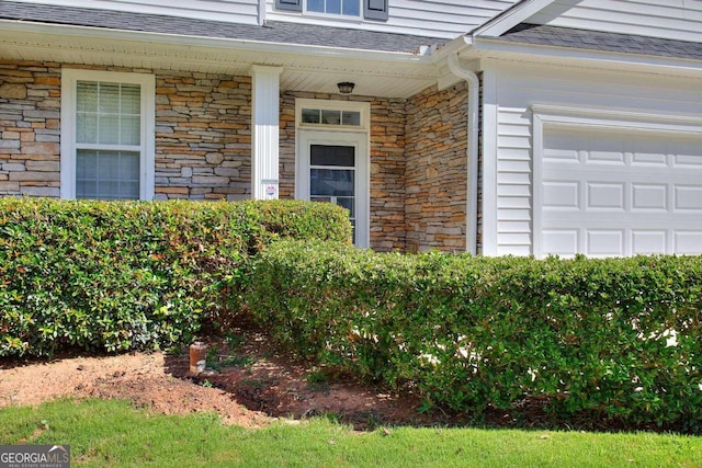 view of exterior entry with a garage