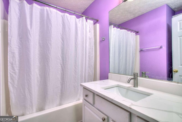 bathroom featuring vanity, a textured ceiling, and shower / bathtub combination with curtain