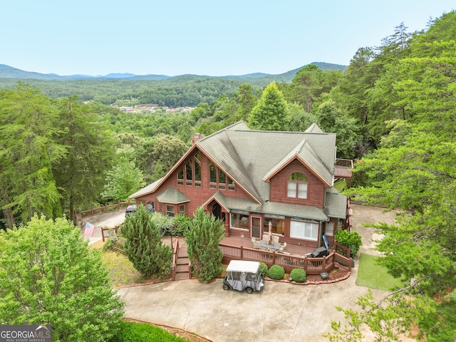 view of front of property with a balcony and a deck with mountain view