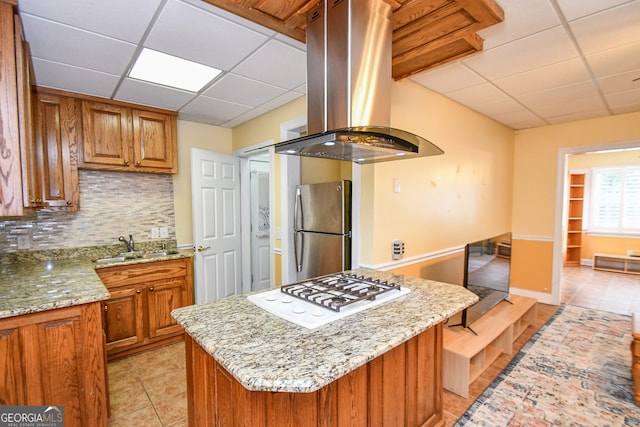 kitchen featuring island exhaust hood, stainless steel fridge, white gas cooktop, and a drop ceiling