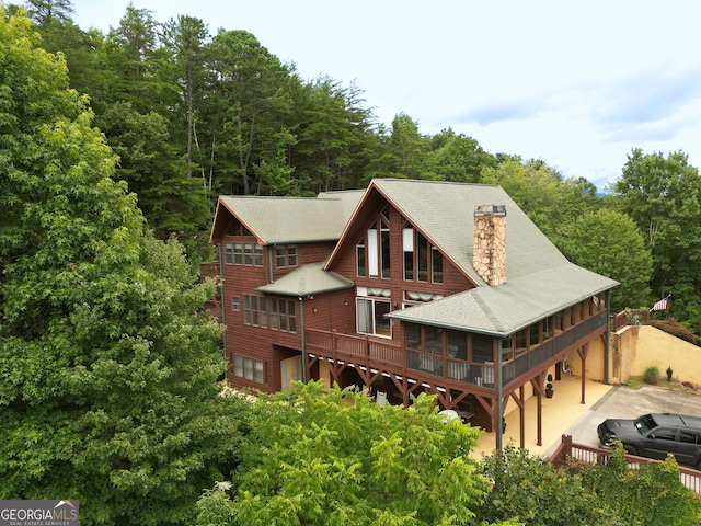 rear view of property featuring a wooden deck and a sunroom