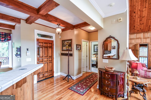 foyer with crown molding, beam ceiling, and light hardwood / wood-style floors