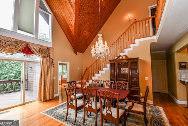 dining room with an inviting chandelier, hardwood / wood-style floors, and a high ceiling