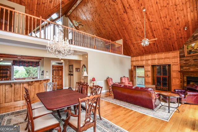 dining area featuring high vaulted ceiling, ceiling fan with notable chandelier, wood-type flooring, and wooden ceiling