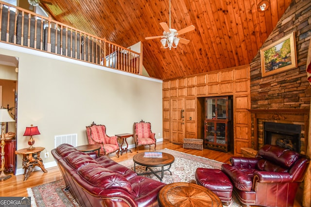 living room with high vaulted ceiling, a fireplace, ceiling fan, wooden ceiling, and light wood-type flooring