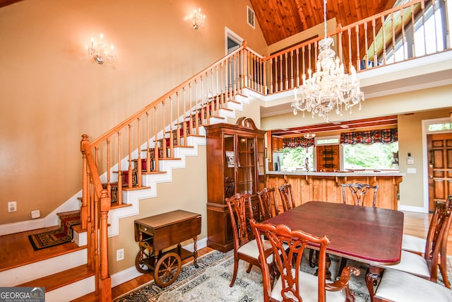 dining space featuring hardwood / wood-style flooring, a high ceiling, and a chandelier