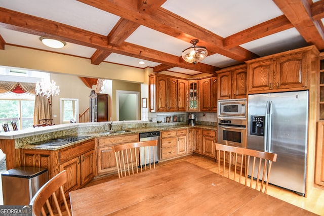 kitchen with coffered ceiling, sink, appliances with stainless steel finishes, stone counters, and light hardwood / wood-style floors