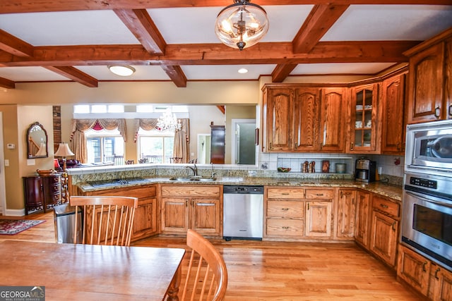 kitchen featuring sink, appliances with stainless steel finishes, a notable chandelier, decorative light fixtures, and light wood-type flooring