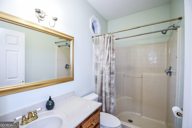 bathroom featuring toilet, vanity, and walk in shower