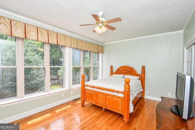 bedroom featuring ornamental molding, ceiling fan, and light wood-type flooring