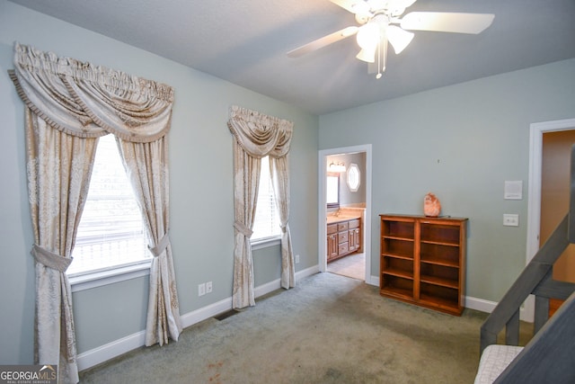 interior space with ceiling fan, light carpet, and a wealth of natural light