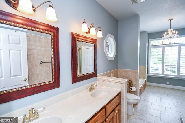 bathroom with vanity, toilet, a chandelier, and a bath