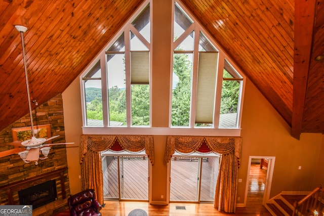 interior space with hardwood / wood-style flooring, high vaulted ceiling, wood ceiling, and a fireplace