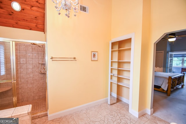 bathroom featuring an enclosed shower, ceiling fan with notable chandelier, wooden ceiling, and a high ceiling