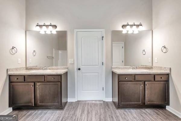 bathroom with dual vanity and wood-type flooring