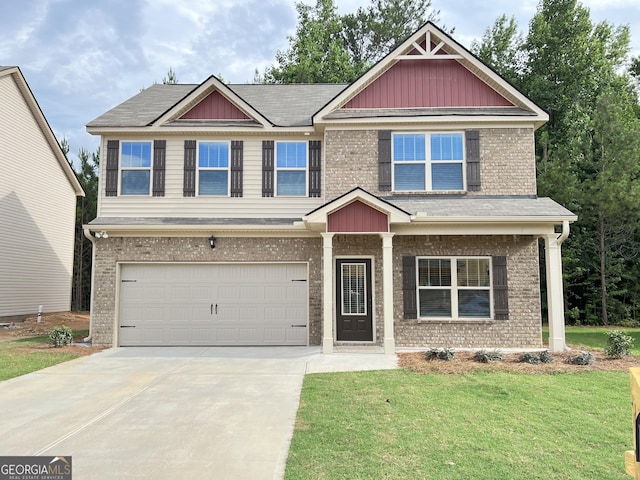 craftsman house featuring a garage, driveway, brick siding, and a front yard