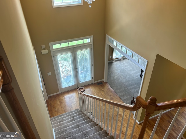 foyer entrance with a high ceiling, french doors, hardwood / wood-style flooring, and a healthy amount of sunlight