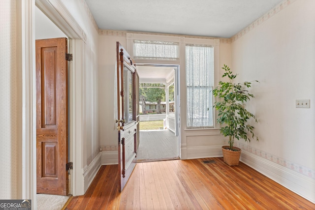 doorway featuring a textured ceiling and hardwood / wood-style flooring