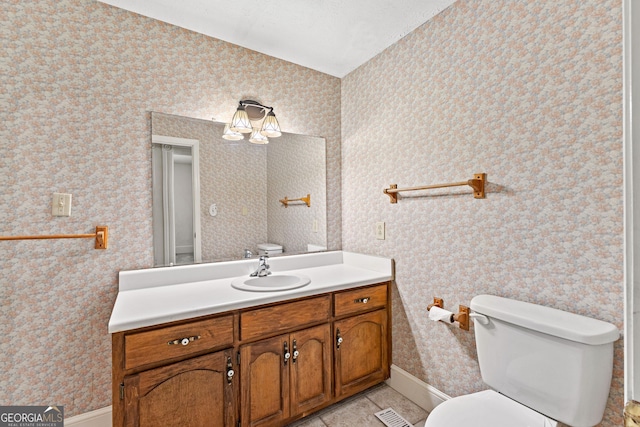 bathroom featuring toilet, vanity, and tile patterned floors