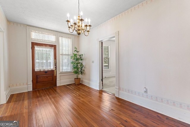 foyer entrance with wood-type flooring and an inviting chandelier