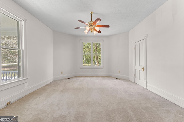 carpeted empty room featuring a textured ceiling and ceiling fan