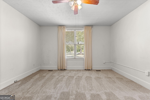 carpeted empty room featuring a textured ceiling and ceiling fan