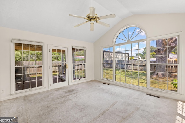 unfurnished sunroom with lofted ceiling, ceiling fan, and plenty of natural light