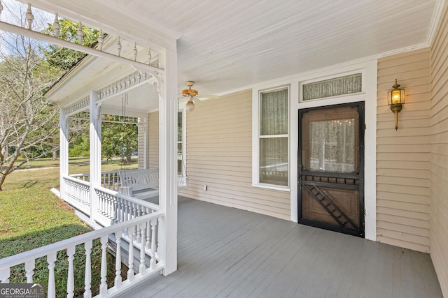 wooden terrace with a porch and ceiling fan