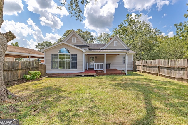 rear view of house featuring a yard and a wooden deck