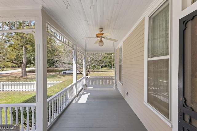 wooden terrace featuring covered porch and ceiling fan