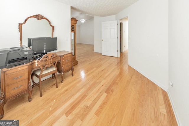 office area with ceiling fan, a textured ceiling, and light hardwood / wood-style floors