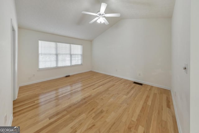 unfurnished room with ceiling fan, lofted ceiling, and light wood-type flooring