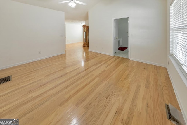 spare room featuring ceiling fan, lofted ceiling, and light hardwood / wood-style floors