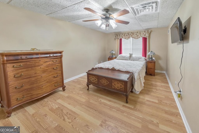 bedroom featuring ceiling fan, a paneled ceiling, and light hardwood / wood-style floors