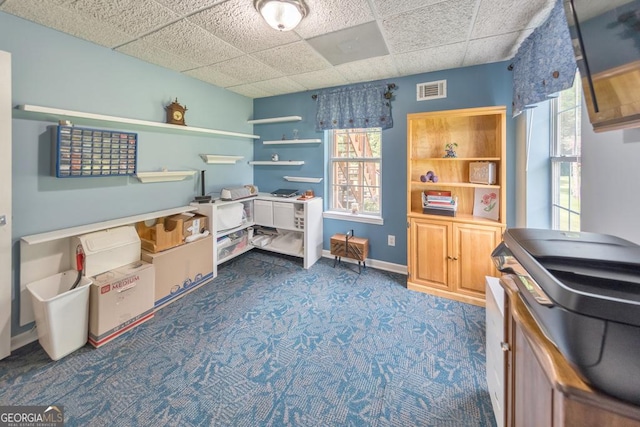 rec room featuring dark colored carpet and a paneled ceiling