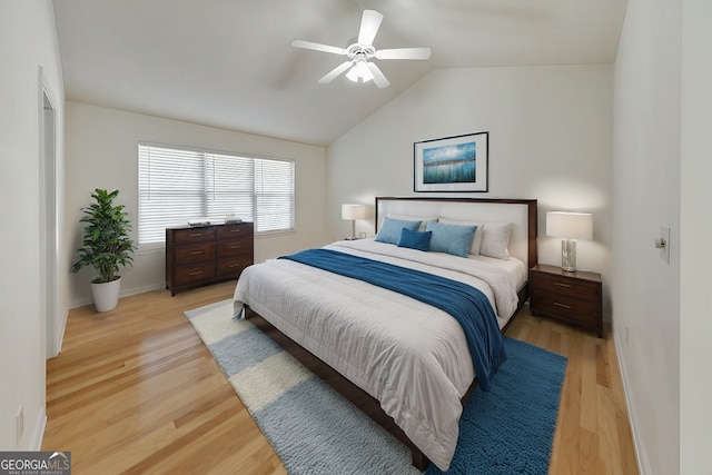 bedroom featuring light hardwood / wood-style flooring, ceiling fan, and vaulted ceiling